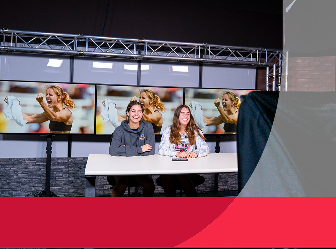 Students in a studio working on a sports broadcast.